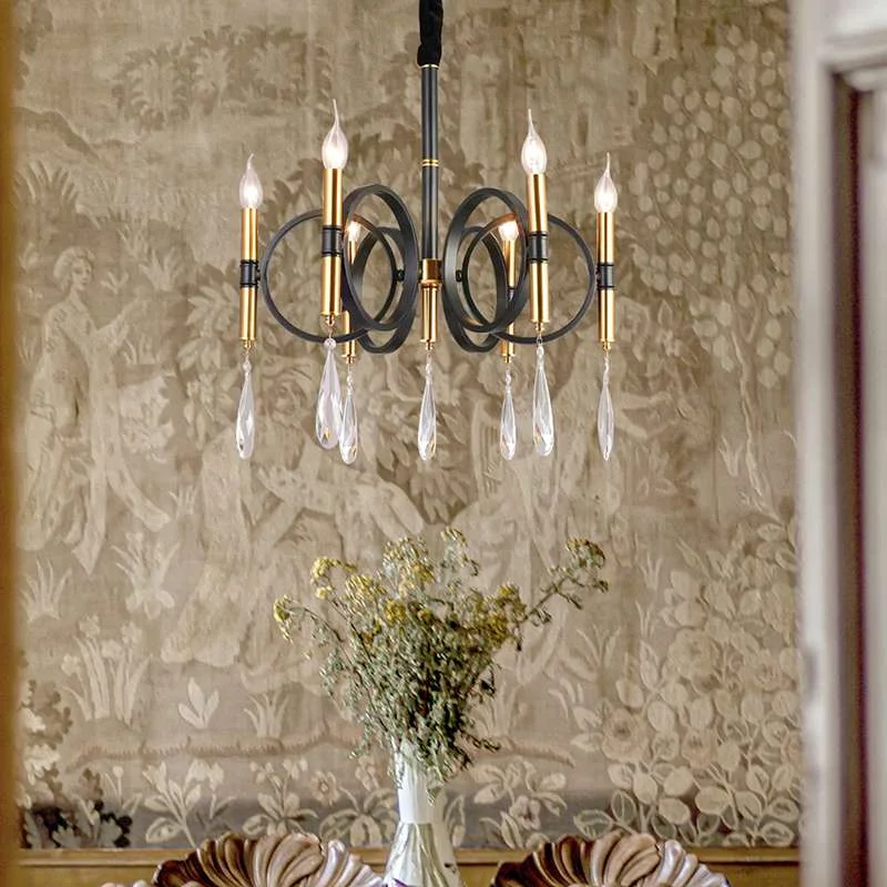 Gold crystal chandelier with six candle shaped lights, metal arms reflecting traditional chandelier lighting on kitchen island