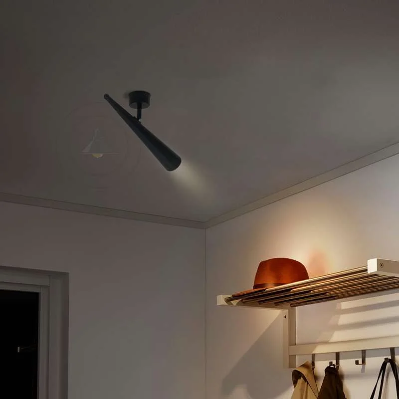 Black adjustable wall light with matte black metal cone sconce that directs spotlight, perfect for modern interior lighting.