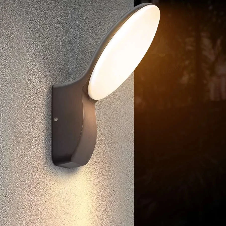 Modern outdoor sconce in black die‑cast aluminium, 17 cm × 21.8 cm, mounted on a wall with warm‑white LED down‑light.