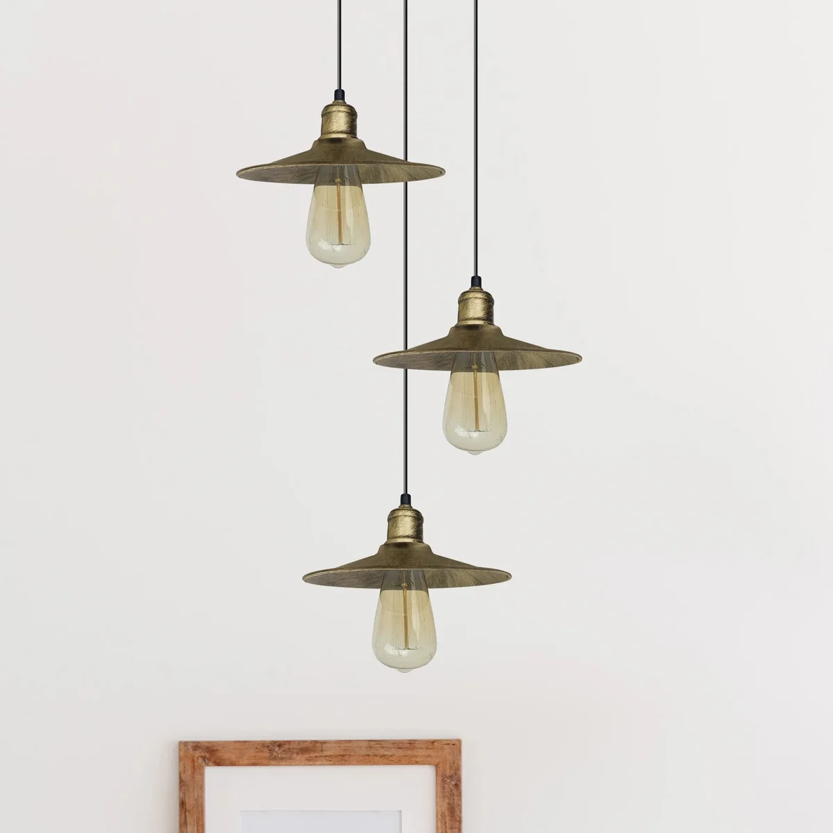 Three brass metal pendant lights hang from a ceiling rose, forming a metal pendant light fixture.