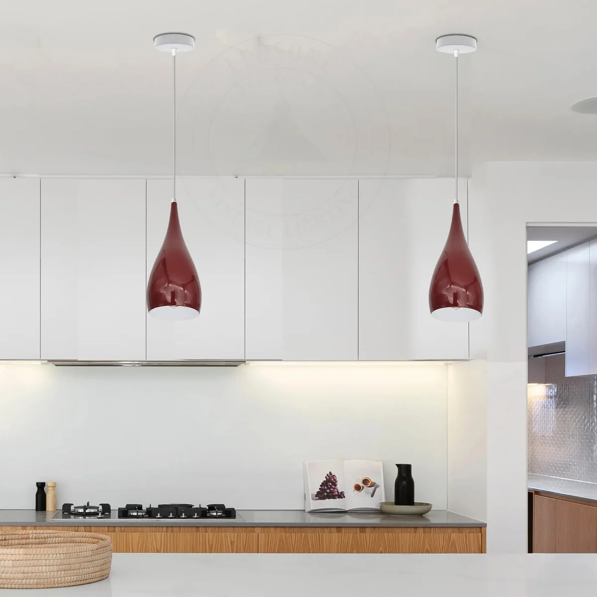 Modern pendant light with teardrop metal shade hanging from ceiling, clear glass LED emitter, silver finish.