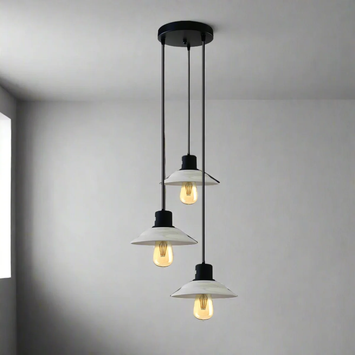 Black and white 3‑light pendant with glossy ceramic shades hanging from ceiling, vintage style