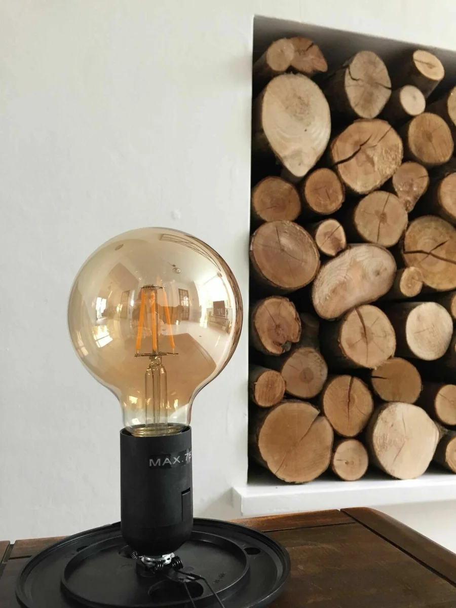 Vintage LED filament bulb in an amber globe, E27 screw fitting, highlighting classic Edison-style filament and warm glow