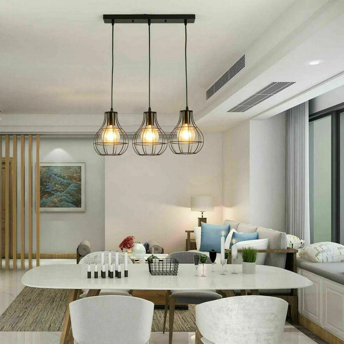 Black 3‑head pendant light with vintage metal cage, three hanging lamps and stained black sockets on a wire base.