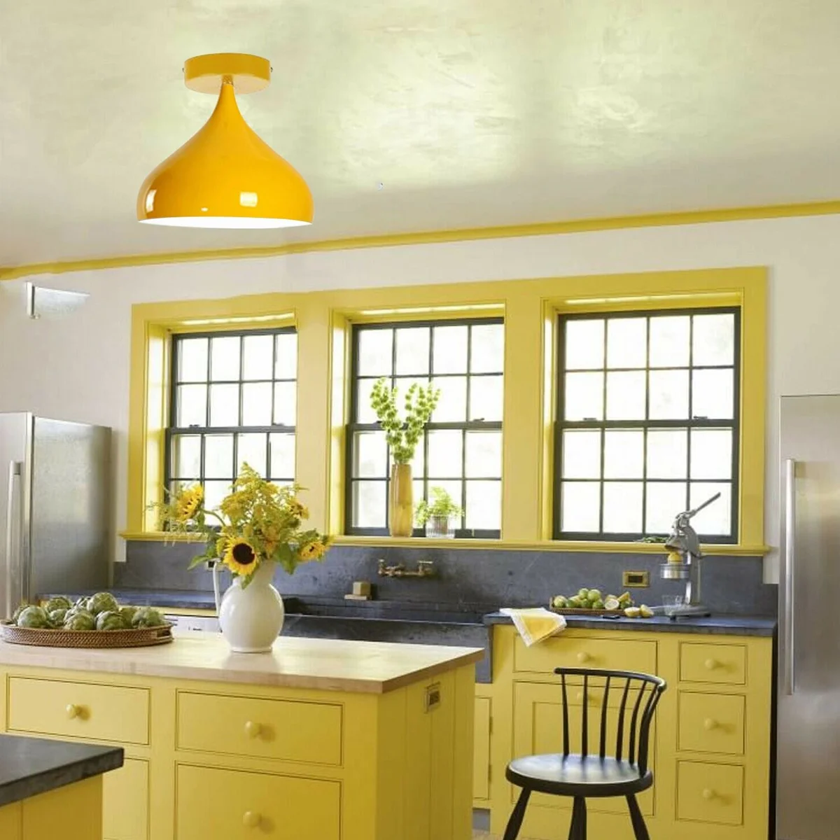 Yellow metal cage ceiling lamp with clear shade hanging as a retro loft pendant light in a modern hotel room.