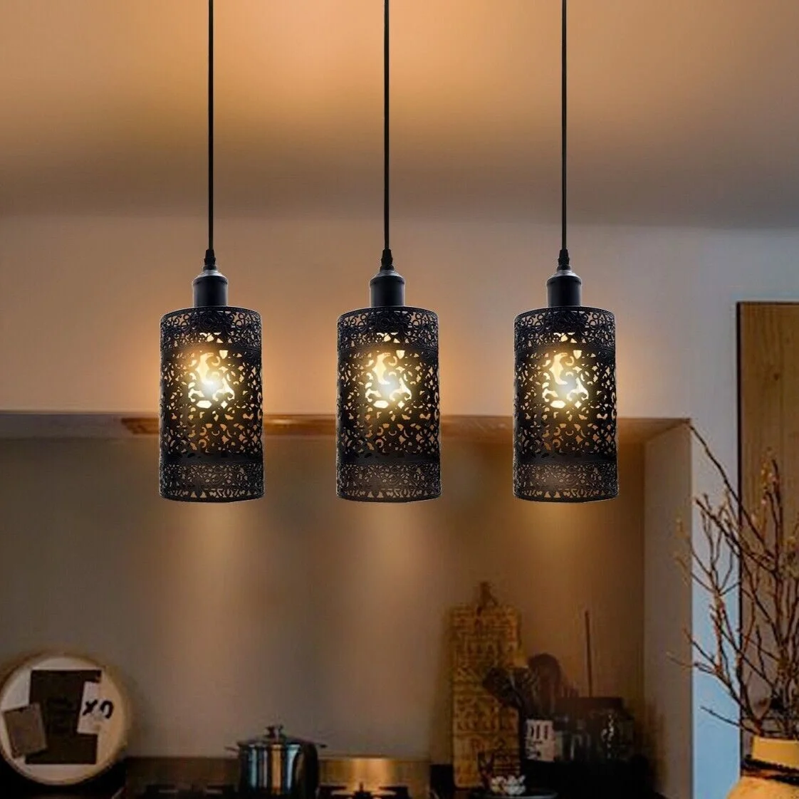 Retro pendant ceiling light with three metal cage shades in brushed silver hanging from the ceiling.