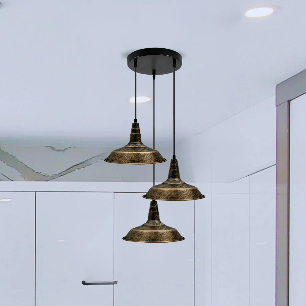3 pendant dining lights in brushed copper and black metal, hanging over a table in a retro style