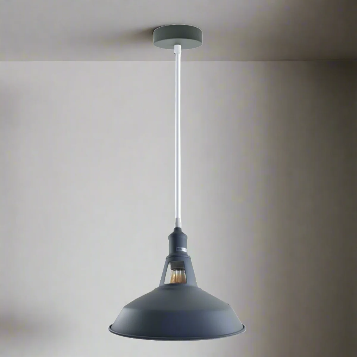 Grey metal industrial pendant light with slotted shade hanging from a ceiling