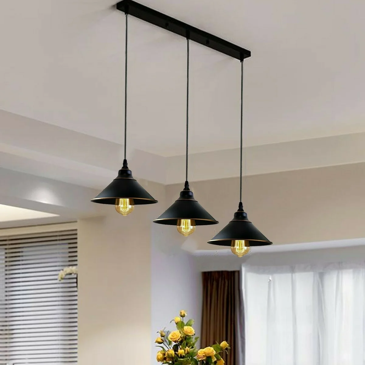 Black industrial pendant light with three curved metal shades and Edison fittings, hung by a 95 cm cable.