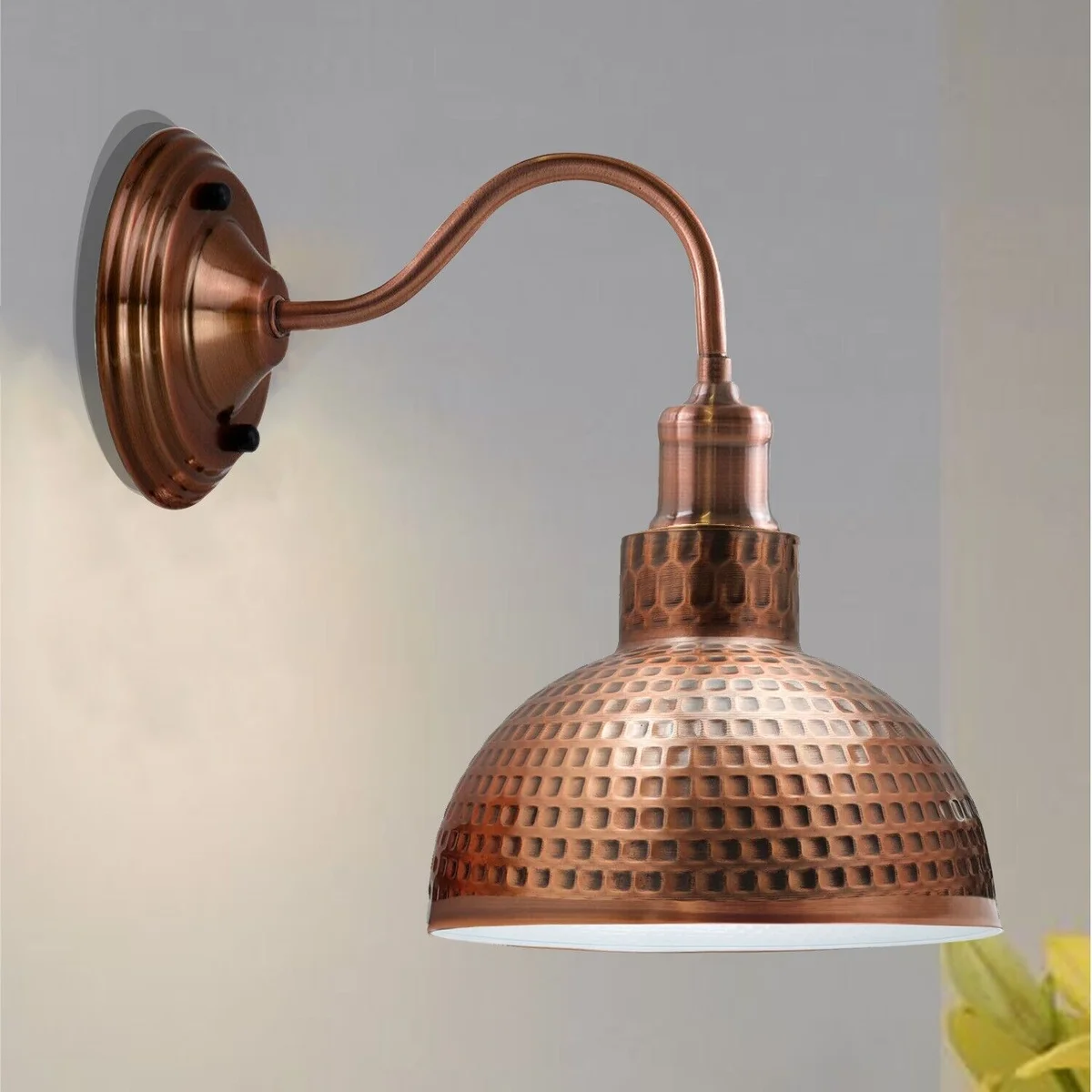 Vintage copper wall light with swan neck mount and metal dome shade, hanging on a wall.