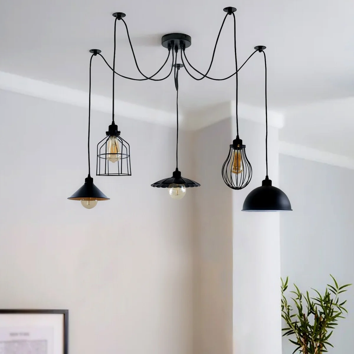Black pendant light with five pendant arms and varied shade styles hanging from a single ceiling point.