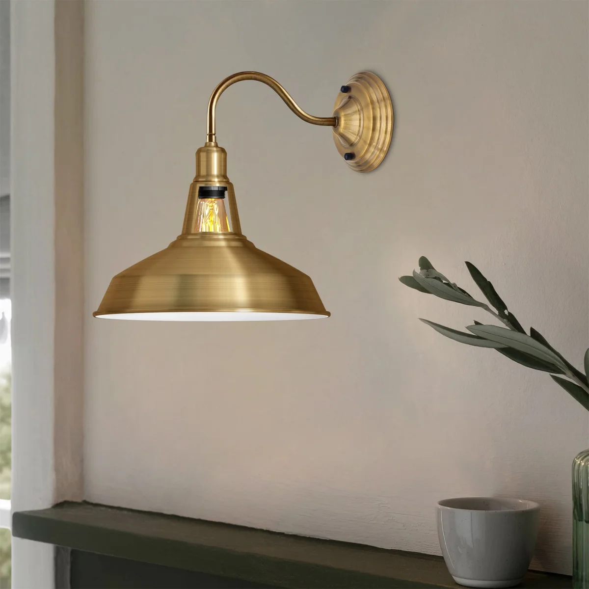 Yellow brass vintage industrial wall light with barn‑shaped shade, polished metal arms and rounded base