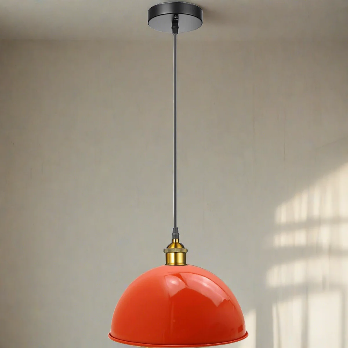 Orange metal pendant light with metal shade, E27 holder, circular ceiling rose, modern minimalist design.