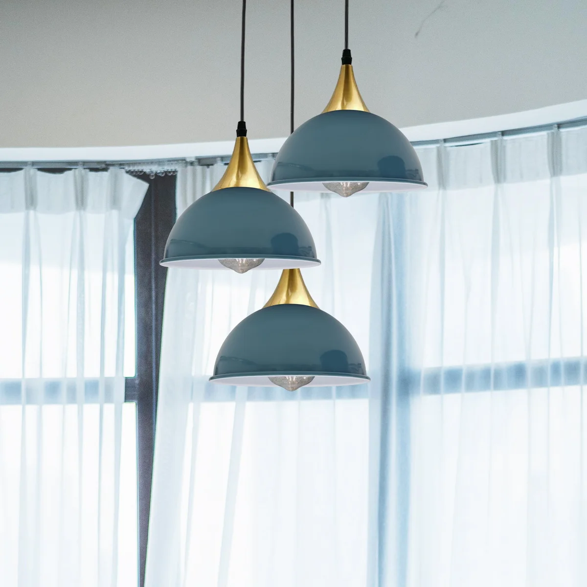 Cyan blue metal shade hanging pendant lamp with brass accents on a white interior