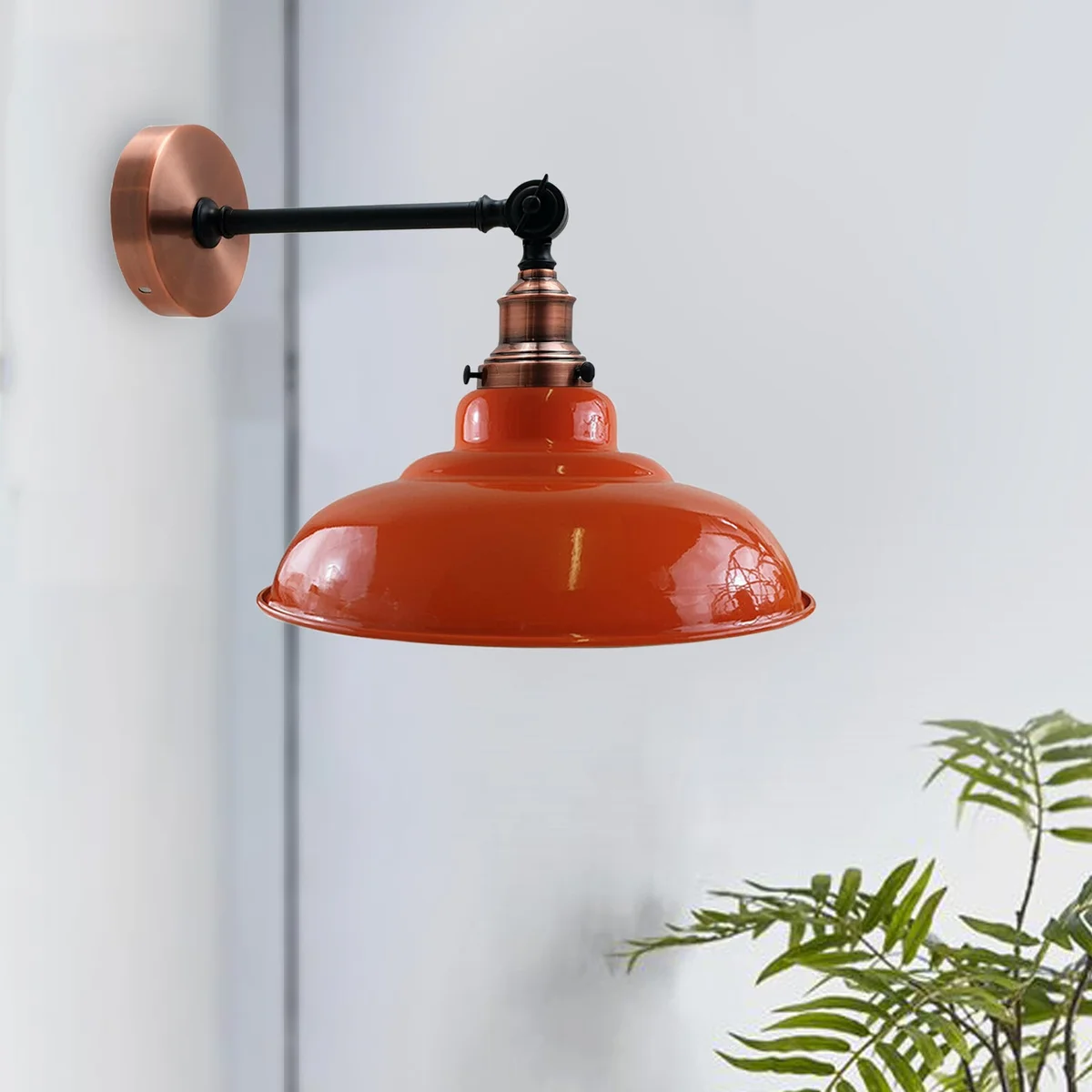 Orange adjustable wall lamp with curved metal shade and swivel arm mounted on wall