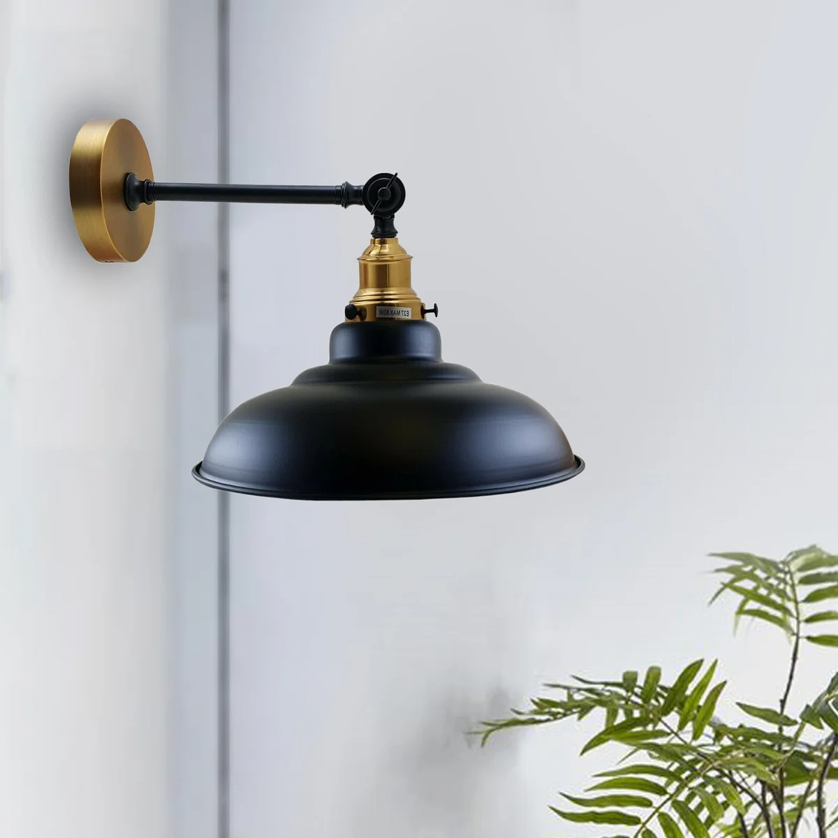 Adjustable vintage wall light with curved metal shade, Edison bulb, and adjustable arm, displayed on a wall.