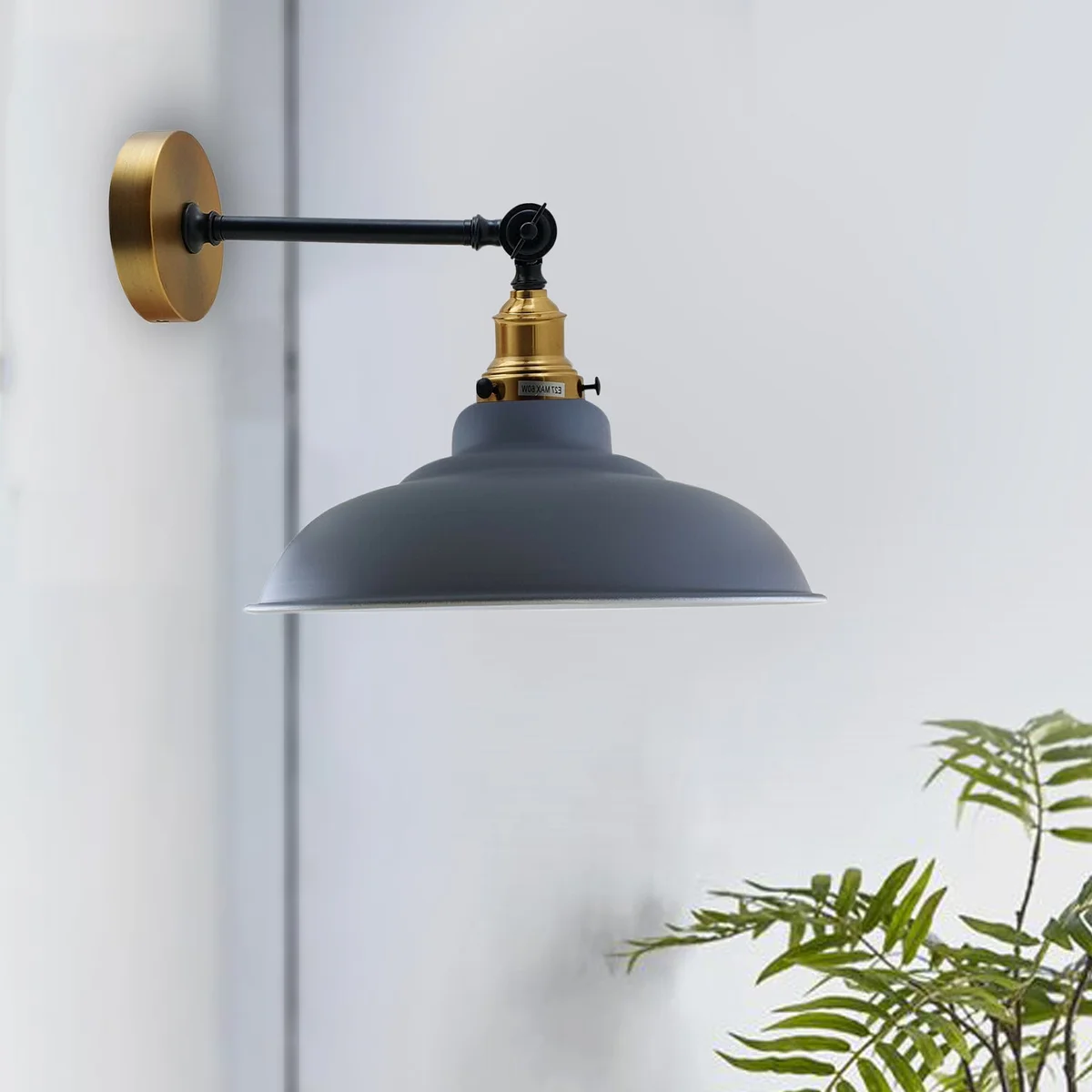 Curved metal adjustable vintage wall light with Edison bulb, mounted on wall, featuring metal shade and adjustable arm.