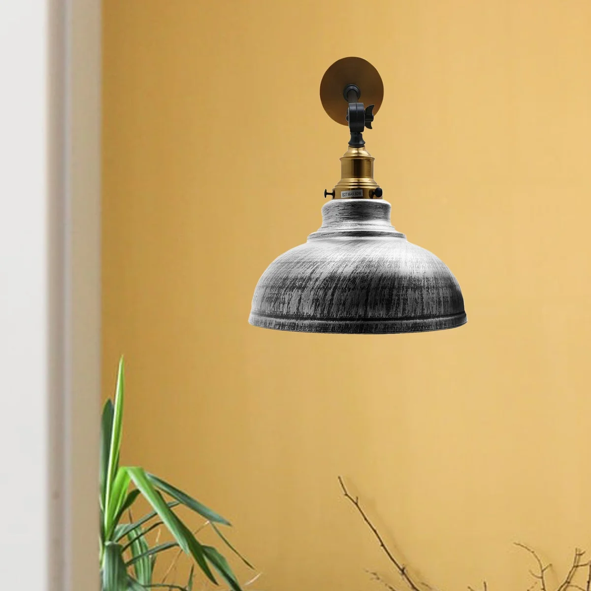 Brushed silver lamp with curved dome metal shade and adjustable wall mount arm, showing a white bulb