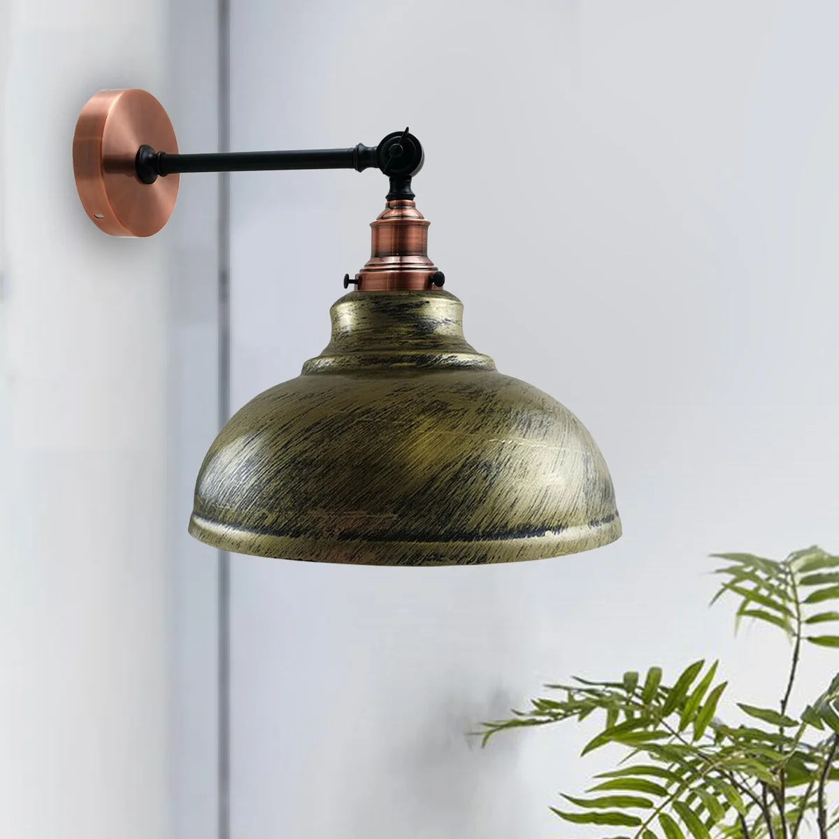 Brushed copper curved dome wall lamp with adjustable metal arm and shade, mounted on wall for modern rustic décor.