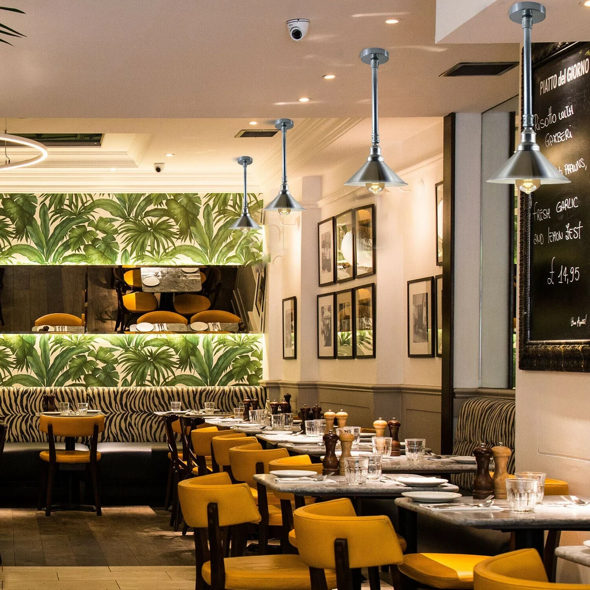 Galvanized pendant shade hanging from ceiling, metal pipe body with white interior, sleek retro industrial design.