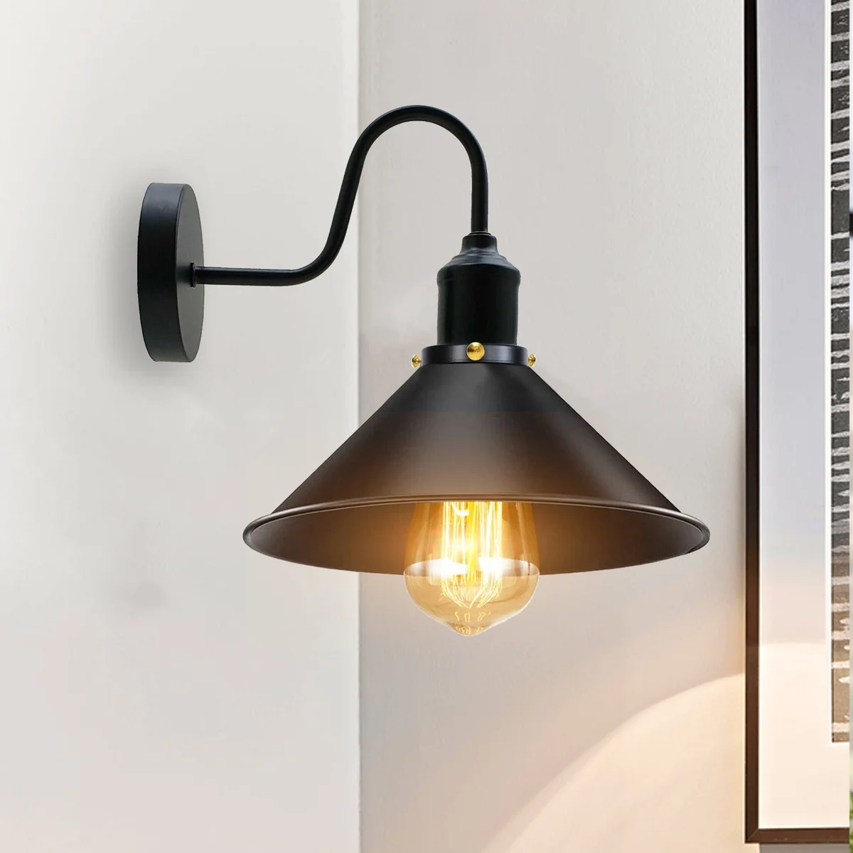 Vintage industrial wall light with metal cone shade in black, featuring a swan neck arm and polished metal lampshade.