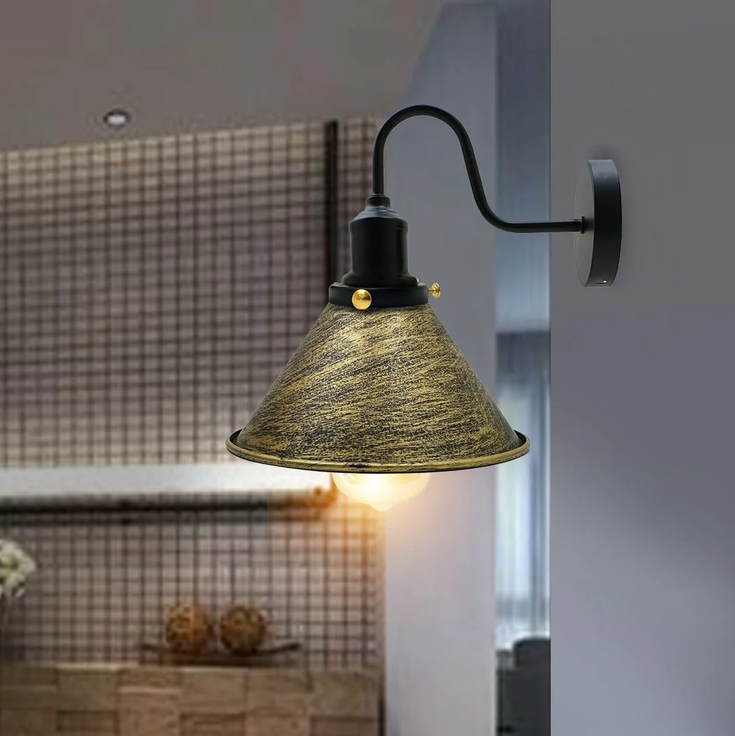 Metal cone wall light with brushed brass shade emits soft ambient lighting, showcasing a sleek retro industrial design.