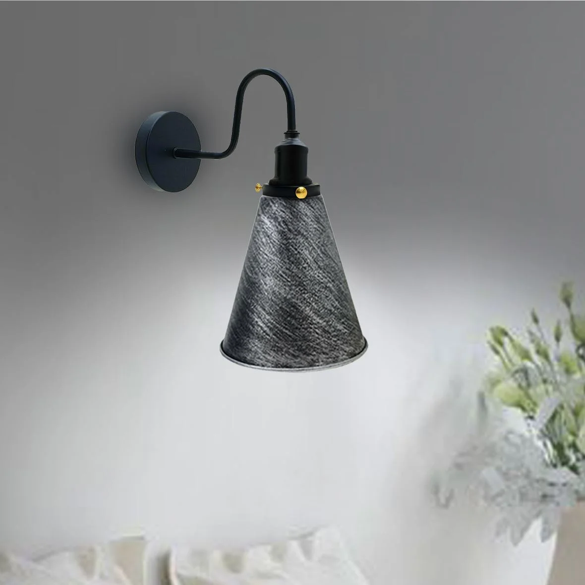 Black vintage industrial wall light in a conical metal shade, mounted on a wall, sleek rustic design