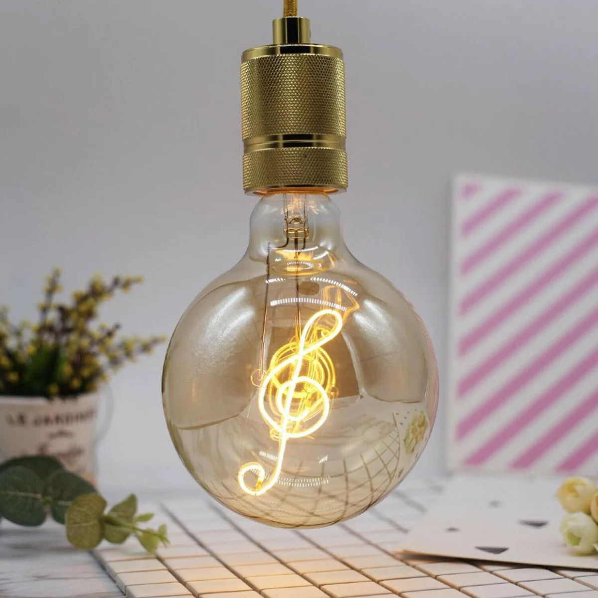 E27 LED bulb with warm white glow, curly filament shaped like musical note inside a glass shell.