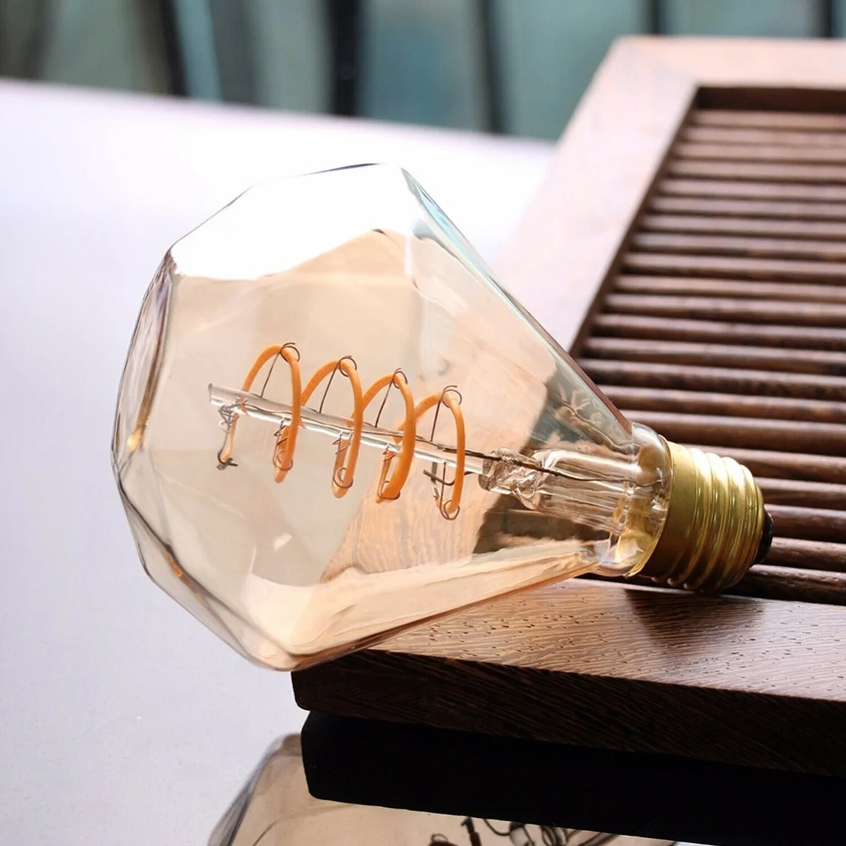 Vintage 4W LED filament bulb with amber glass and pure copper cap, showcasing curved filament.