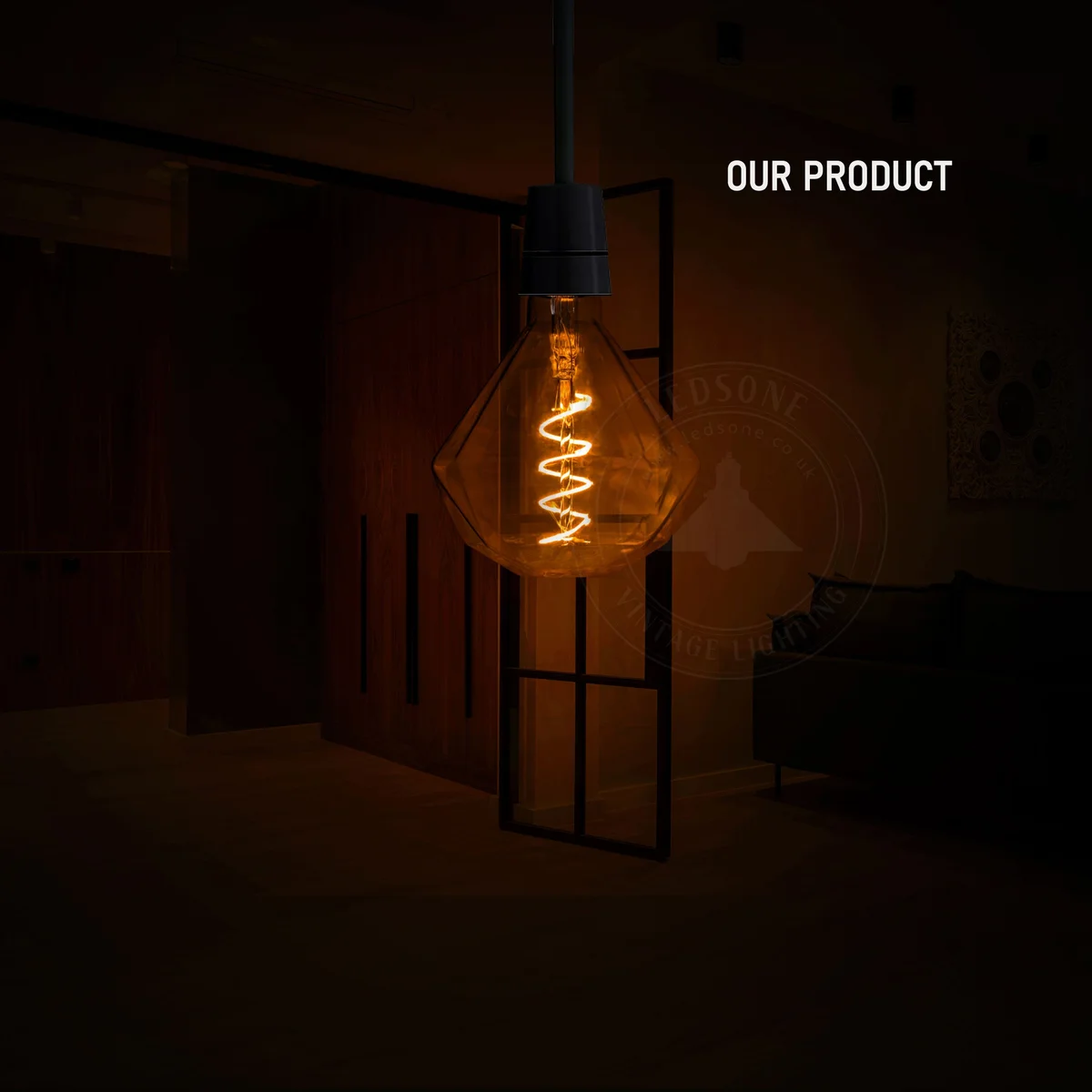 Gold‑copper capped vintage LED filament bulb with amber glass and curly filament, glowing warmly.