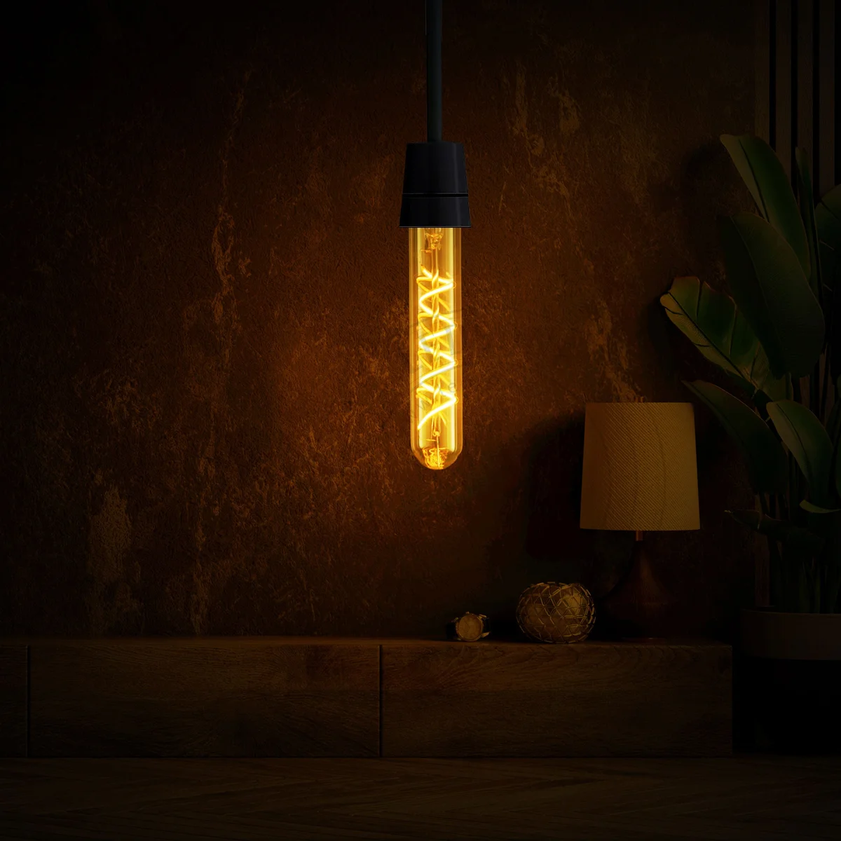Transparent amber vintage LED filament bulb with metal B22 base, glowing softly, on a dark background.