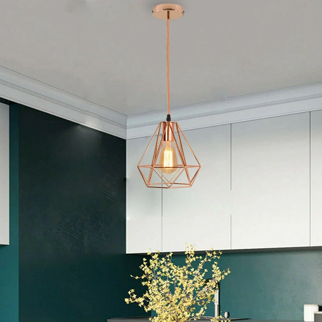 Rose gold pendant light with metal cage and diamond finish hanging from ceiling