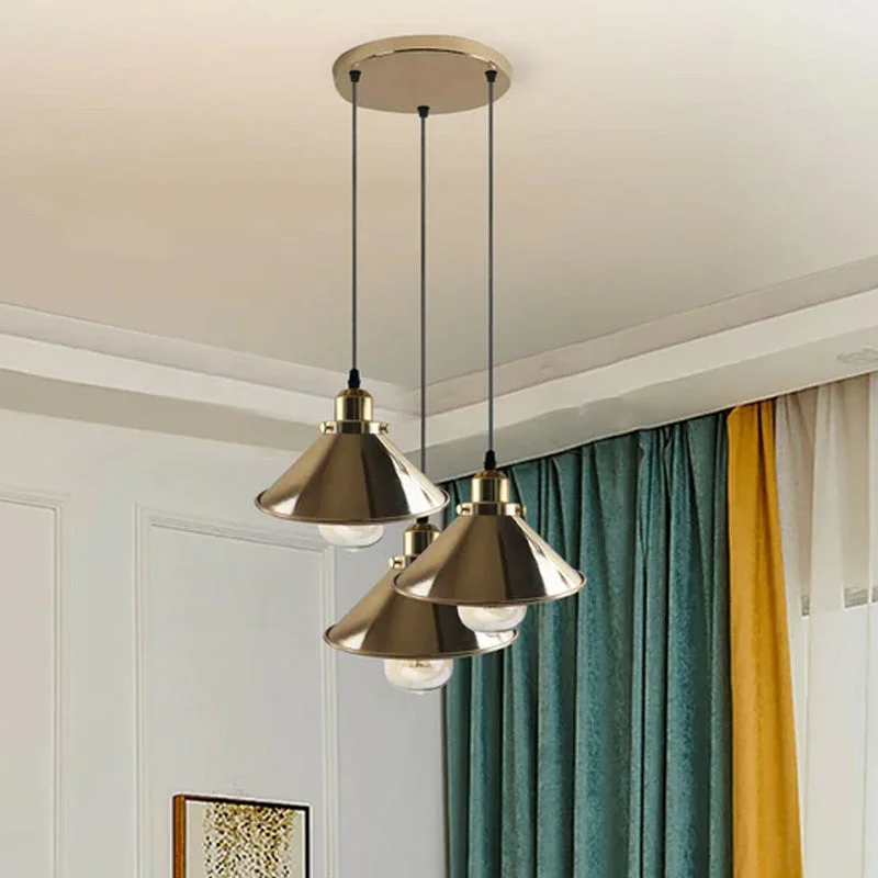 Modern French gold pendant light with metal cone shade hanging on ceiling in a stylish room.