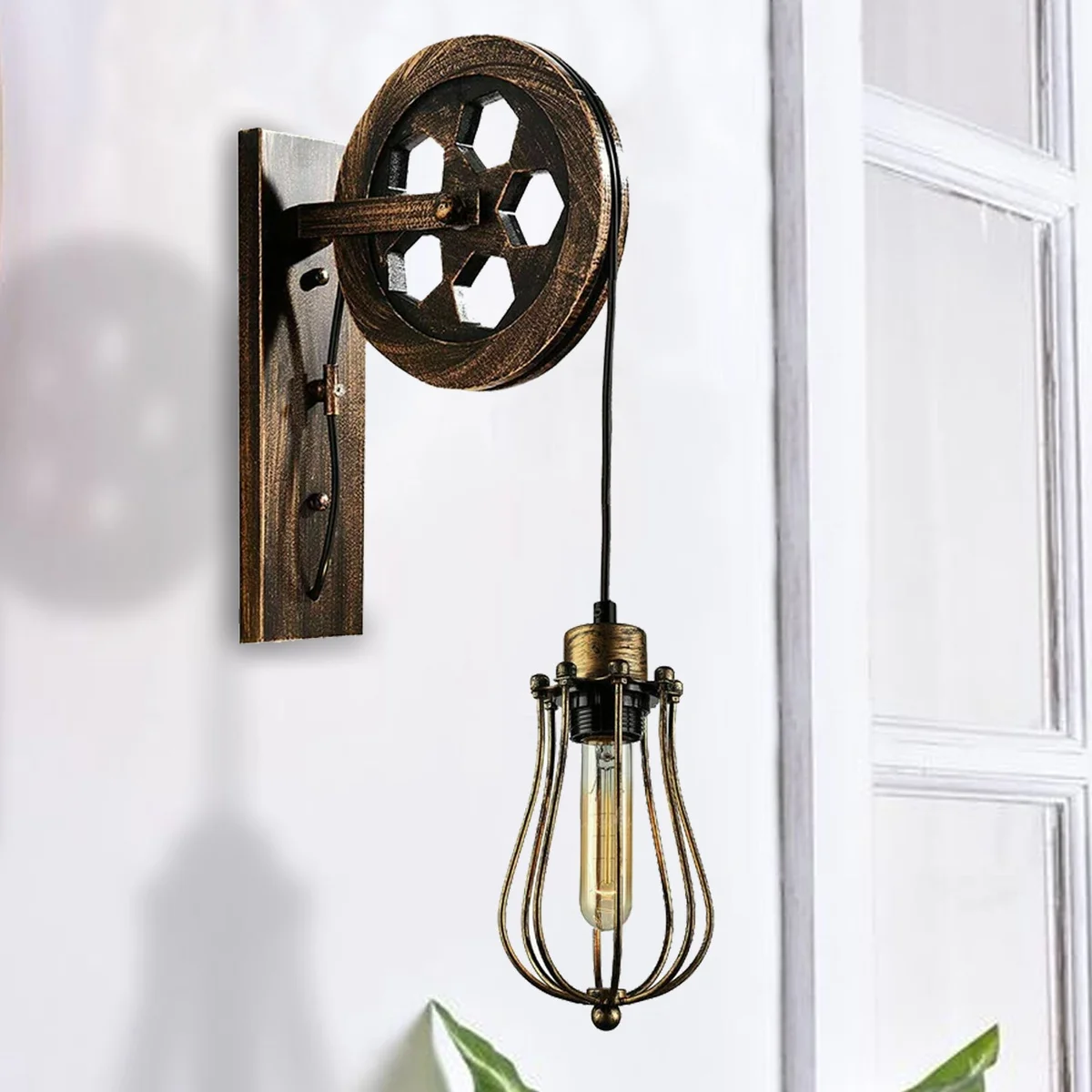 Retro industrial wall lamp with pulley wheel, metal balloon cage shade, adjustable hanging cable, black metal finish.