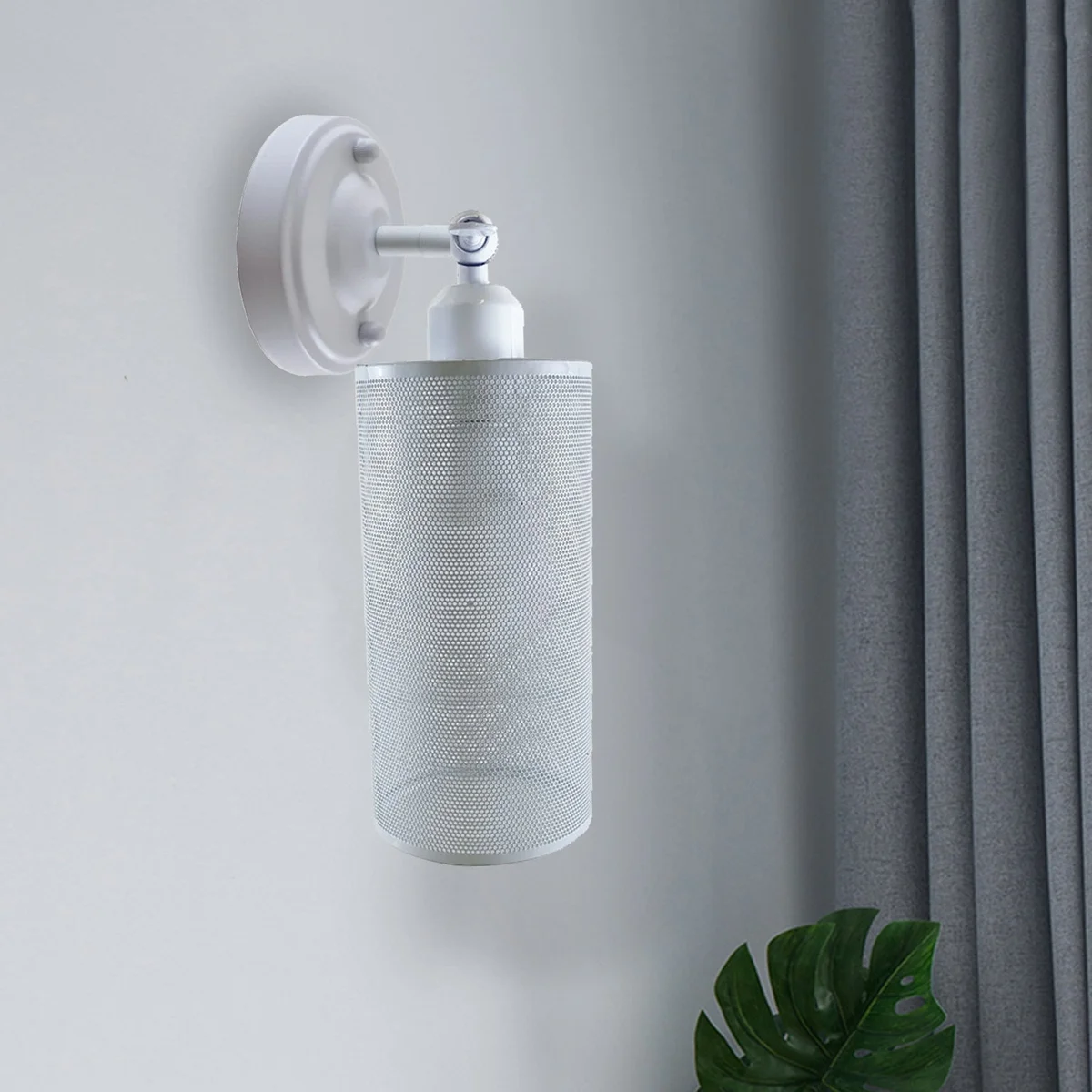 White vintage metal wall lamp with adjustable arm and cylinder shade, installed on wall.