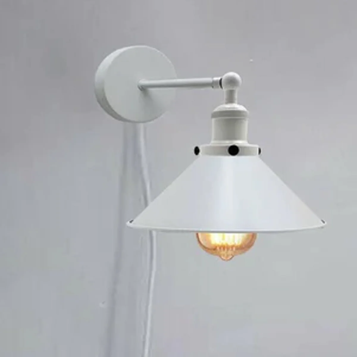 White iron plug in wall sconce with lamp shade and cord, UK plug visible