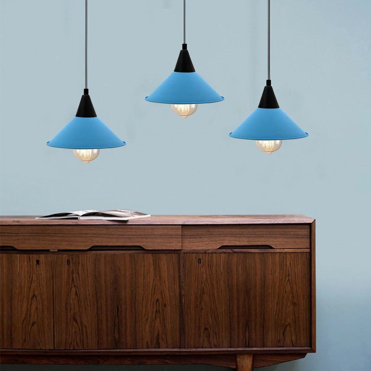 Retro cone pendant light with painted metal cone shade hanging from angled ceiling plate, glowing over kitchen island