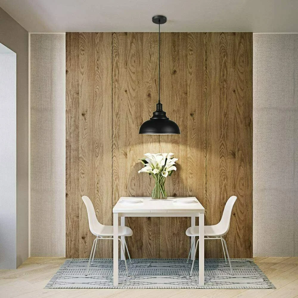 Black iron pendant light with slotted‑style shade and 95 cm adjustable cable pendant light hanging over a dining area.