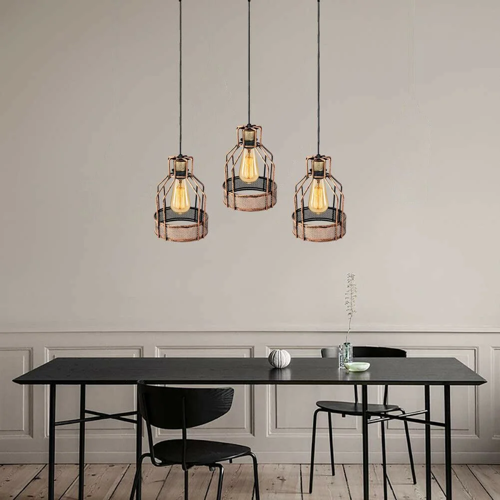 Vintage 3‑head hanging pendant light in brushed copper, bird‑cage shape, hanging from ceiling with long PVC cable, warm.