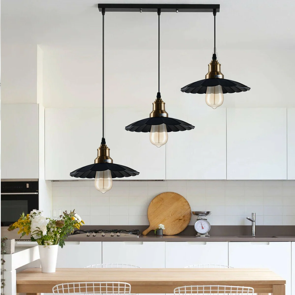 Black pendant light featuring three gold holders and a metal base, hanging from a ceiling.