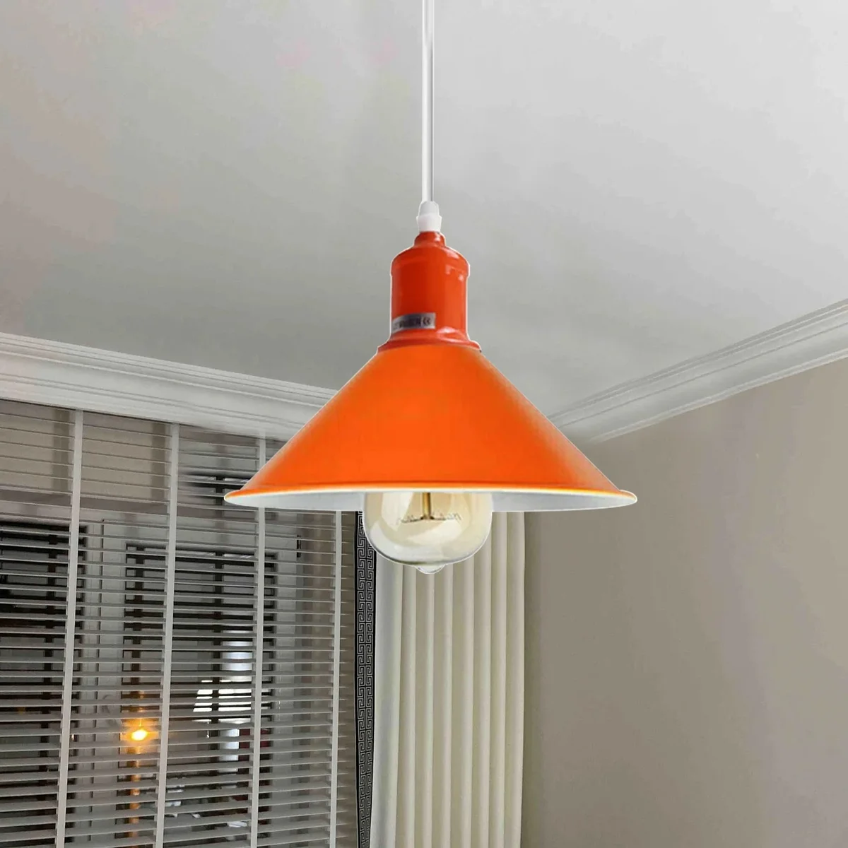 Orange metal pendant light with polished silver dome, hanging from ceiling, approx 22cm diameter, 115cm height.