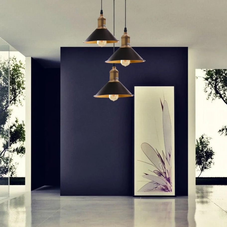 Black pendant light with three metal yellow brass shades, hanging 95 cm PVC cable from ceiling.