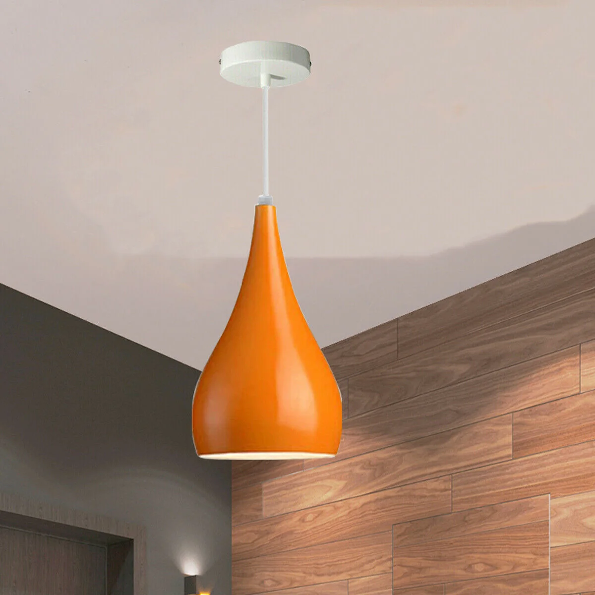 Black and orange industrial pendant light with teardrop metal shade and brushed nickel interior, mounted on ceiling.