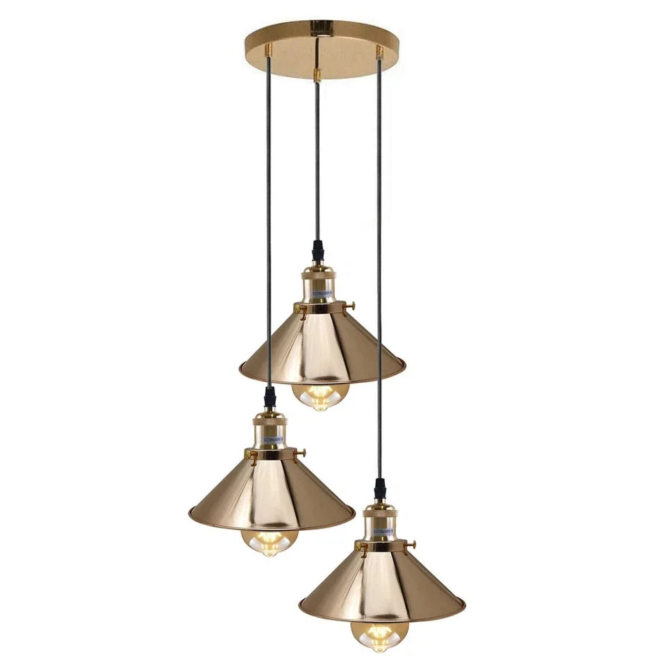 Three French gold ceiling lights with flat metal shades on adjustable cables, minimalist vintage industrial style.