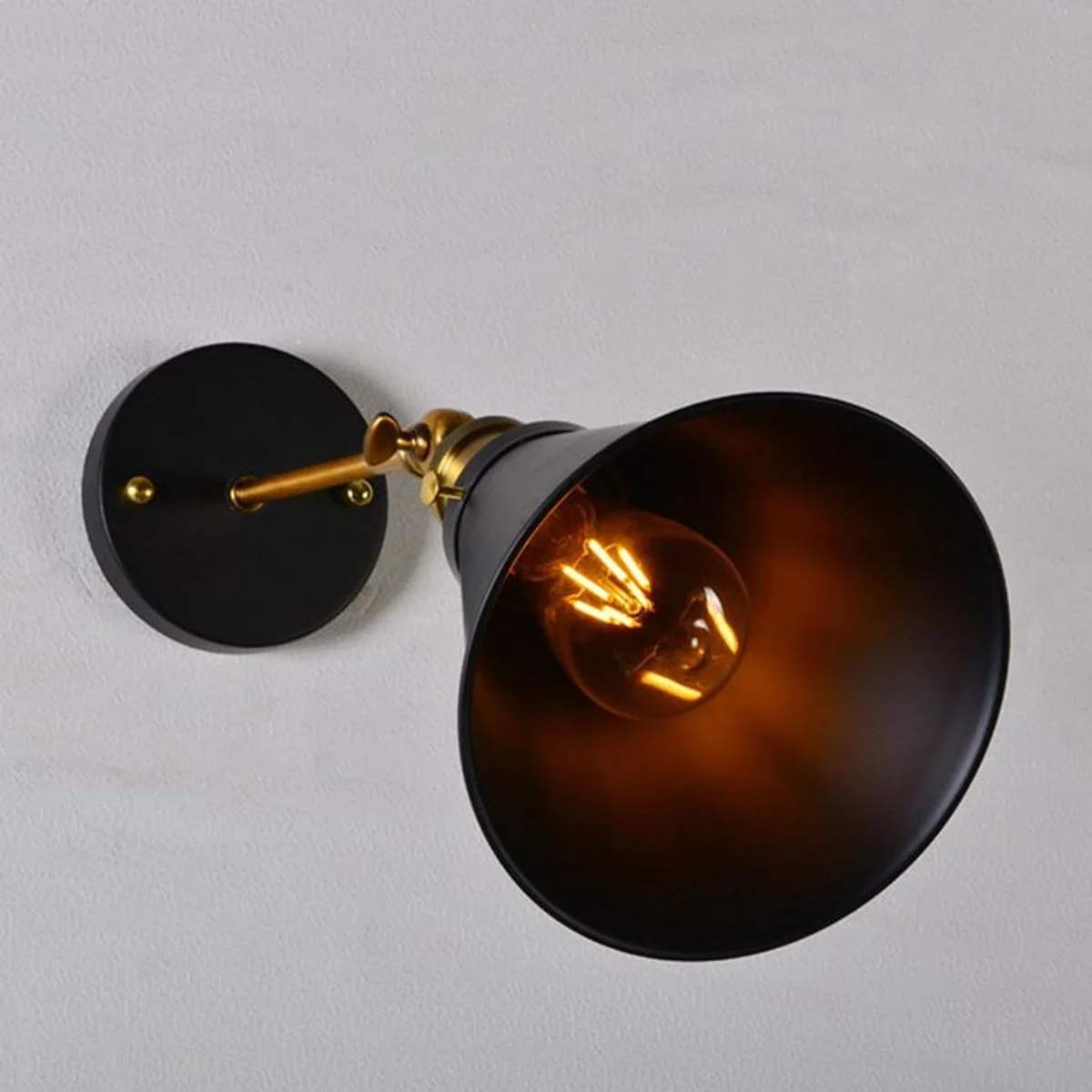 Black vintage industrial wall light with adjustable cone shade, brass arm and black ceiling rose – a hard wired wall light for indoor use.