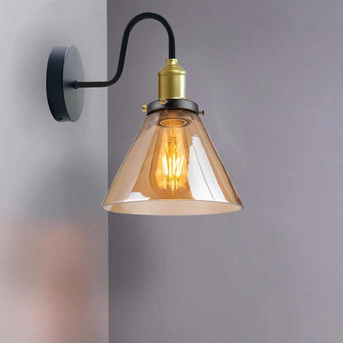 Amber glass wall light with chrome plate base, cone-shaped amber shade, vertical fixture on wall, modern style.