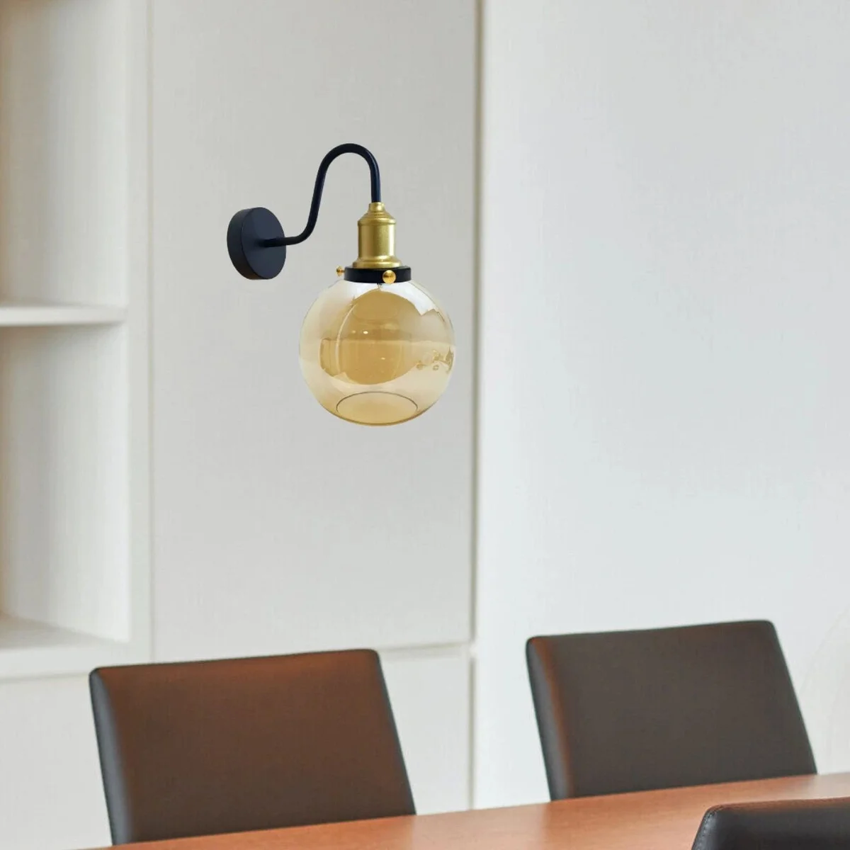 Amber glass globe wall light with metal base, modern style for indoor wall lighting in living rooms and bedrooms.