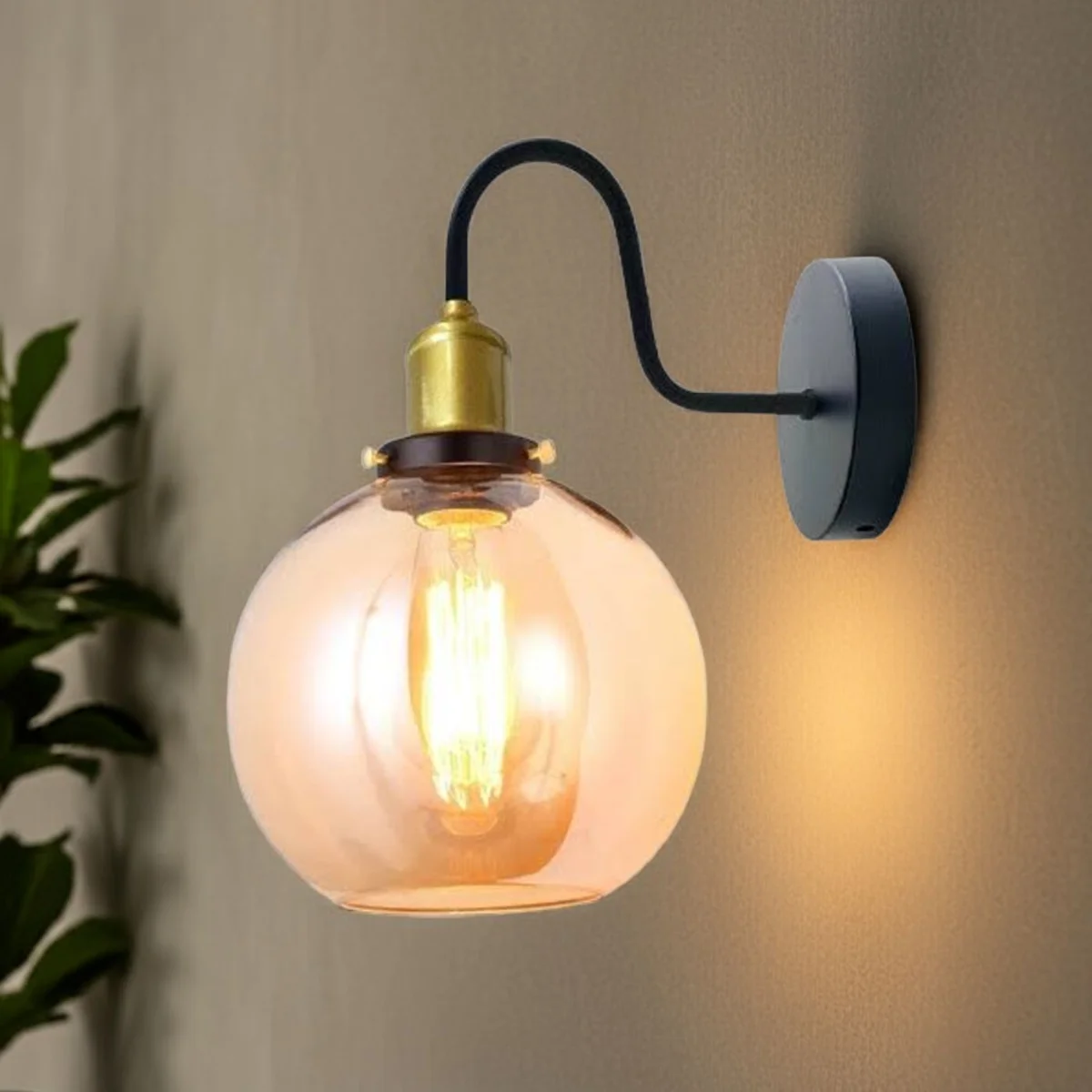Modern amber glass wall light with globe shade mounted on wall, metal back plate supporting 20 cm amber glass globe.