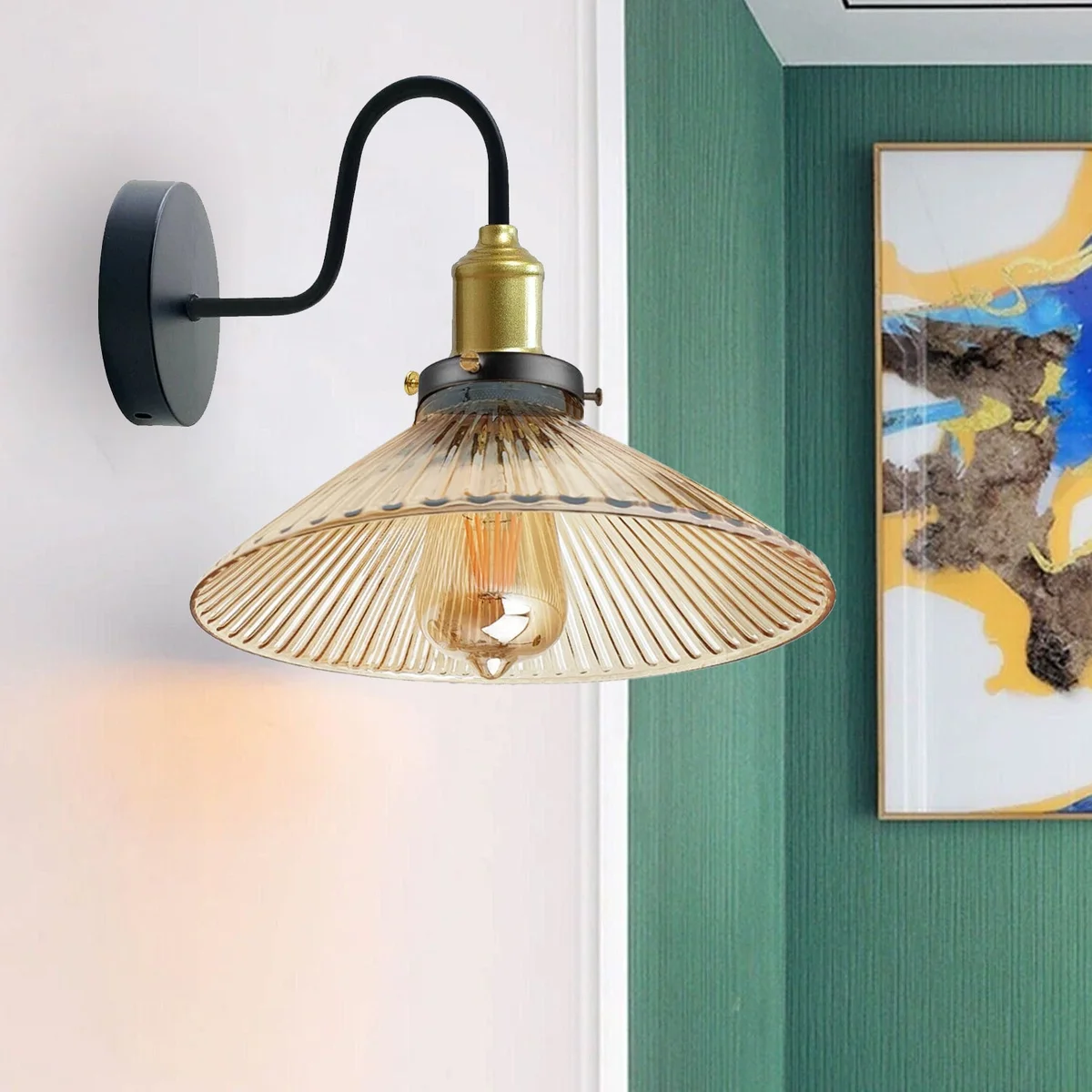 Amber glass wall light with metal base and rimmed glass shade, emitting warm amber glow from wall-mounted fixture.