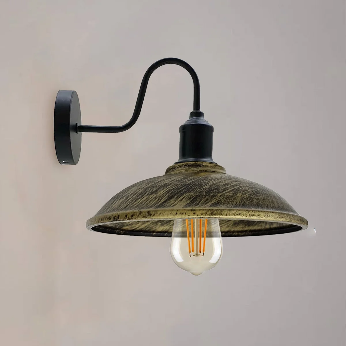 Industrial wall light with vintage metal cage shade, black arm, and brushed brass finish, wall-mounted E27 fitting